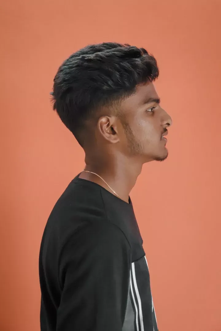 Teen boy in profile with a neat fade and textured top
